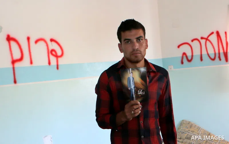 Palestinian Firas Abu Toaimeh, 26, holds a picture of his brother Mohammed Abu Toaimeh, 22, at his house which was hit by Israeli shelling during the war, in Khan Yunis town in the southern Gaza Strip, on September 18, 2...