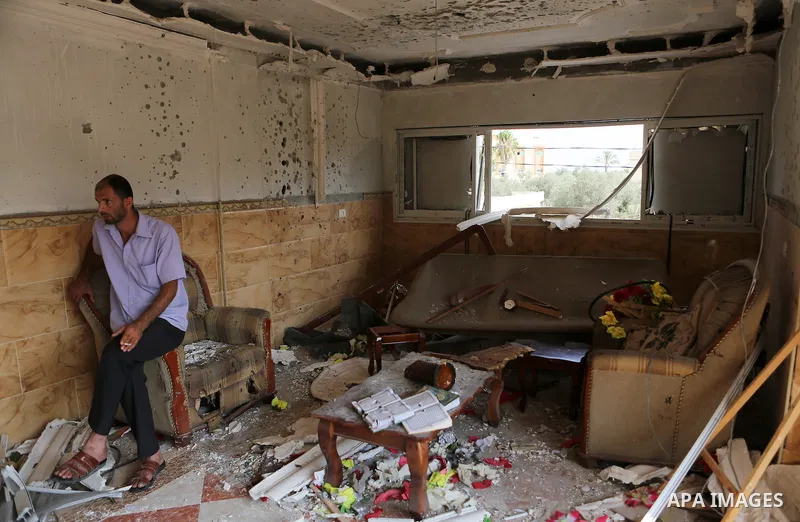 Palestinian relative of Hussein al-Jorf, 19, sits at his house which was hit by Israeli shelling during the war, in Khan Yunis town in the southern Gaza Strip, on September 18, 2014. Hussein al-Jorf, and other Gazans are...