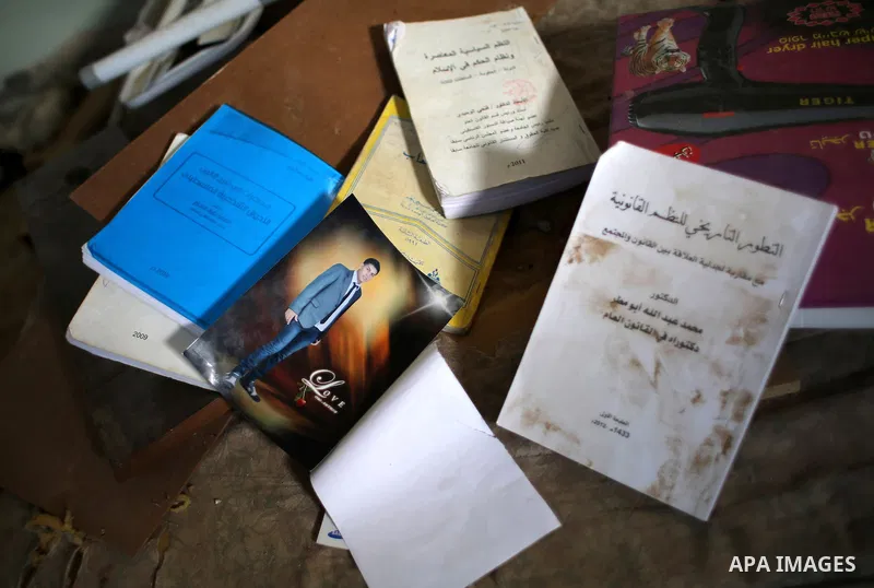 The picture of Mohammed Abu Toaimeh, 22, is seen netween his books at his house which was hit by Israeli shelling during the war, in Khan Yunis town in the southern Gaza Strip, on September 18, 2014. Hussein al-Jorf, and...