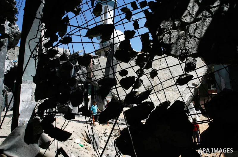Palestinian boys searche in the rubble of the heavily damaged al-Faruq mosque which was destroyed by Israeli strikes during the summer's fierce offensive, in Rafah in the southern Gaza Strip September 21, 2014. Photo by...
