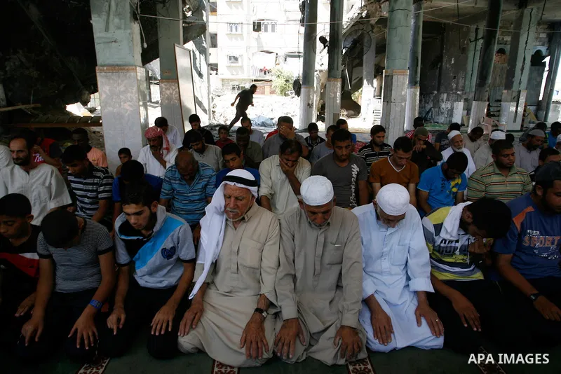 Palestinian Muslims hold noon prayers at the heavily damaged al-Faruq mosque which was destroyed by Israeli strikes during the summer's fierce offensive, in Rafah in the southern Gaza Strip September 21, 2014. Photo by A...