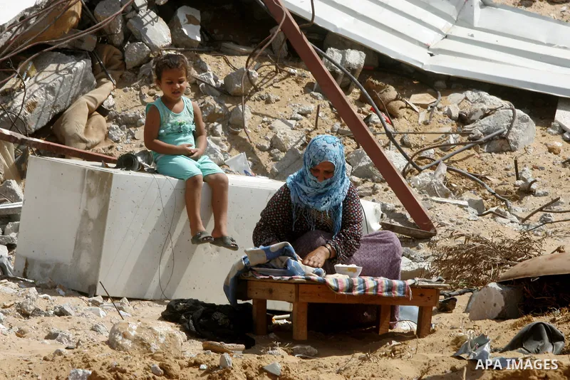 A Palestinian woman bakes bread on the firewood amid the rubble of her destroyed house in the town of Khan Younis in the southern Gaza Strip, Sep. 21, 2014. Gazans who endured more than 50 days of devastating Israeli bom...
