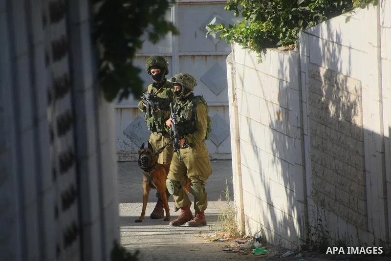 Israeli soldiers take position during clashes with Palestinians in the West Bank city of Hebron September 23, 2014. Israeli troops shot dead two Palestinians in the West Bank city of Hebron on Tuesday and the military sa...