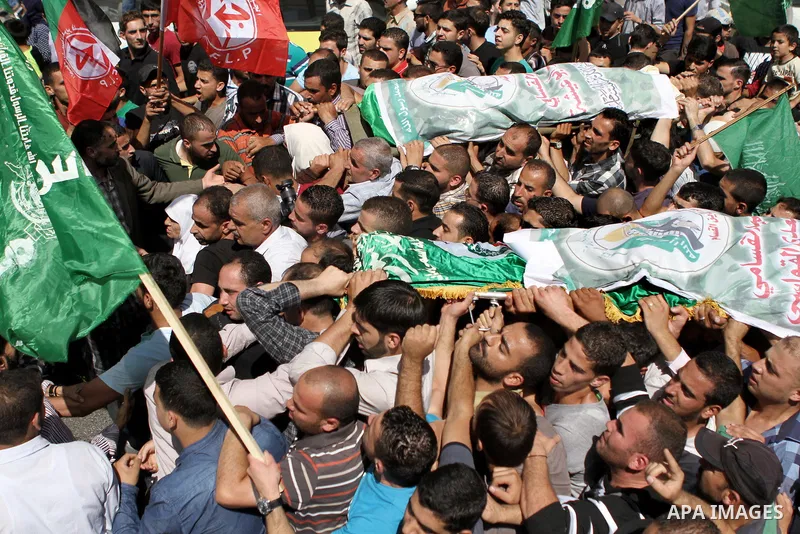 Palestinians carry the coffins of Marwan Kawasme and Amar Abu Aysha, Palestinians shot dead by Israeli troops, during their funeral in the West Bank city of Hebron September 23, 2014. Israeli troops shot dead two Palesti...