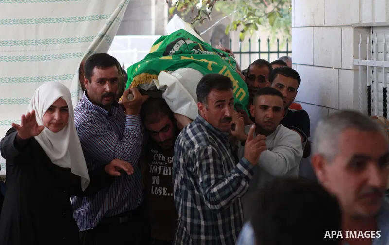 The mother of Amar Abu Aysha, a Palestinian shot dead by Israeli troops, reacts in front of her son's body during his funeral in the West Bank city of Hebron September 23, 2014. Israeli troops shot dead two Palestinians,...