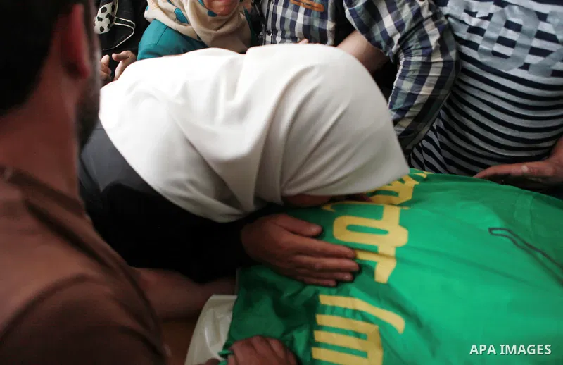 The mother of Amar Abu Aysha, a Palestinian shot dead by Israeli troops, kisses her son's body during his funeral in the West Bank city of Hebron September 23, 2014. Israeli troops shot dead two Palestinians, including A...