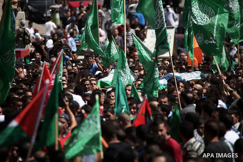 The mother of Amar Abu Aysha, a Palestinian shot dead by Israeli troops, carries her son's coffin during his funeral in the West Bank city of Hebron September 23, 2014. Israeli troops shot dead two Palestinians, includin...