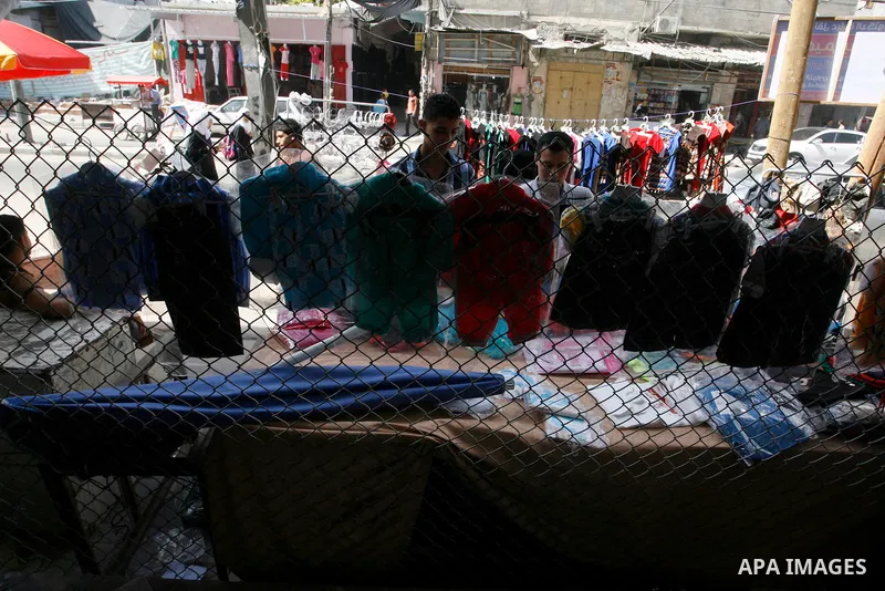 Palestinians shop in front of the heavily damaged commercial center which was destroyed by Israeli strikes during the summer's fierce offensive, in Rafah in the southern Gaza Strip September 23, 2014. Gazans who endured...