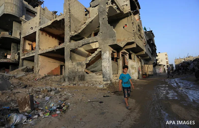 A Palestinian boy walks in front of the rubbles of damaged houses which were destroyed by Israeli strikes during the summer's fierce offensive, at Shejaiya neighborhood in the east of Gaza city, Sep. 24, 2014. Head of th...