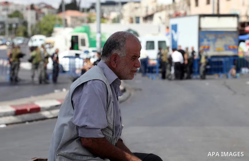 A Palestinian man waits as Israeli policemen block Palestinians from praying in the city's Al-Aqsa mosque, in the Ras Al-Amud neighborhood of East Jerusalem on Spe. 26, 2014. Israeli police stepped up security around the...