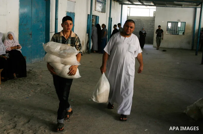 Palestinians receive food supplies from a distribution centre of the United Nations Relief and Works Agency (UNRWA) in Rafah in southern Gaza strip on Sept. 28, 2014. The aid was sent to the U.N. office to be distributed...