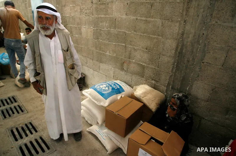 A Palestinian man receives food supplies from a distribution centre of the United Nations Relief and Works Agency (UNRWA) in Rafah in southern Gaza strip on Sept. 28, 2014. The aid was sent to the U.N. office to be distr...