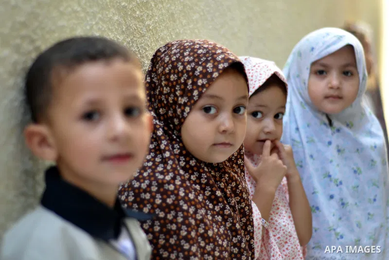 Palestinian children gather around a makeshift cube representing the holy Kaaba in Gaza city, on Sept. 30, 2014, as part of training children how to perform Hajj pilgrimage. Muslims from around the world flood Saudi city...