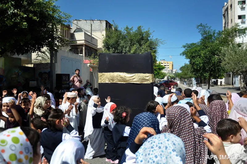 Palestinian children gather around a makeshift cube representing the holy Kaaba in Gaza city, on Sept. 30, 2014, as part of training children how to perform Hajj pilgrimage. Muslims from around the world flood Saudi city...