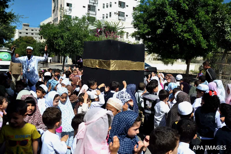 Palestinian children gather around a makeshift cube representing the holy Kaaba in Gaza city, on Sept. 30, 2014, as part of training children how to perform Hajj pilgrimage. Muslims from around the world flood Saudi city...