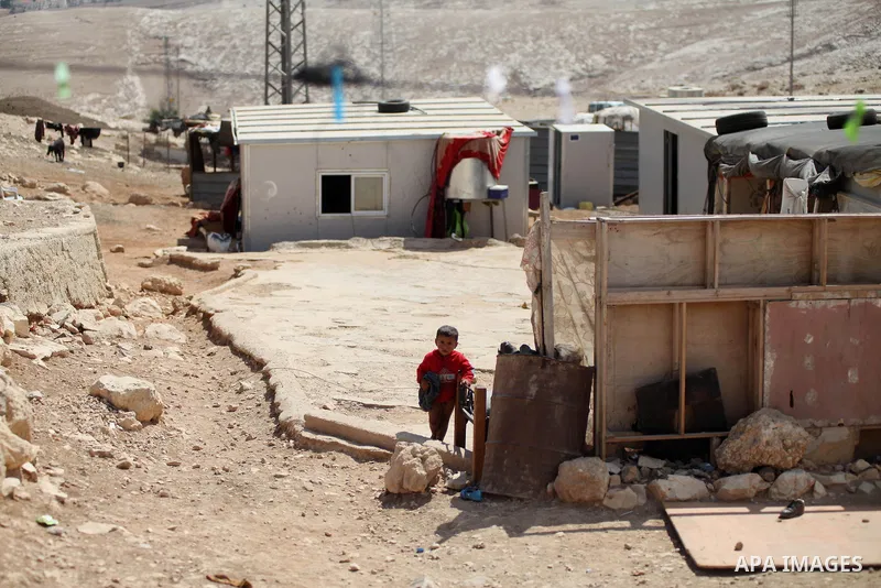 A Palestinian Bedouin boy plays at his family's dwellings, in the West Bank village of Al-Eizariya, near east of Jerusalem, on Septemper 30, 2014. Israel's Civil Administration in the West Bank is advancing a plan to exp...