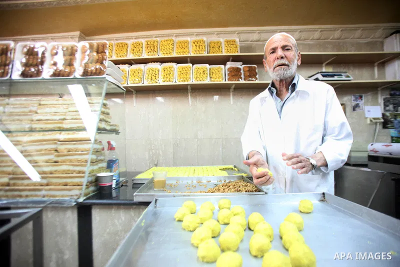 A Palestinian man prepare cake at his shop during the preparation for the Eid al-Adha festival in Jerusalem, Sept. 30, 2014. Muslims worldwide are celebrating Eid al-Adha, or Feast of the Sacrifice, commemorating God's p...