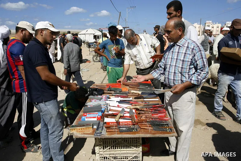 Palestinians buy knifes at a livestock market, days before the major Muslim festival of Eid al-Adha, in Khan Younis in the southern Gaza Strip on October 1, 2014. During the first week of October, Muslims across the worl...