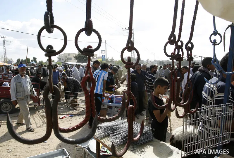Palestinians gather at a livestock market, days before the major Muslim festival of Eid al-Adha, in Khan Younis in the southern Gaza Strip on October 1, 2014. During the first week of October, Muslims across the world wi...