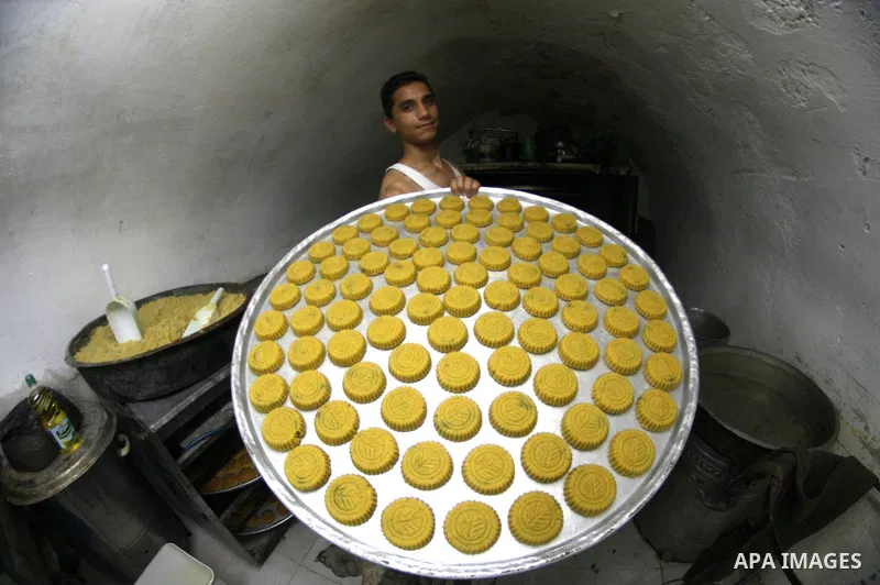 A Palestinian worker makes traditional date-filled cookies during the preparation for the Eid al-Adha festival in the West Bank city of Nablus, Oct. 02, 2014. Muslims worldwide are celebrating Eid al-Adha, or Feast of th...