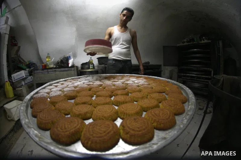 A Palestinian worker makes traditional date-filled cookies during the preparation for the Eid al-Adha festival in the West Bank city of Nablus, Oct. 02, 2014. Muslims worldwide are celebrating Eid al-Adha, or Feast of th...