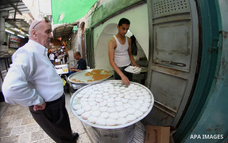 A Palestinian worker makes traditional date-filled cookies during the preparation for the Eid al-Adha festival in the West Bank city of Nablus, Oct. 02, 2014. Muslims worldwide are celebrating Eid al-Adha, or Feast of th...