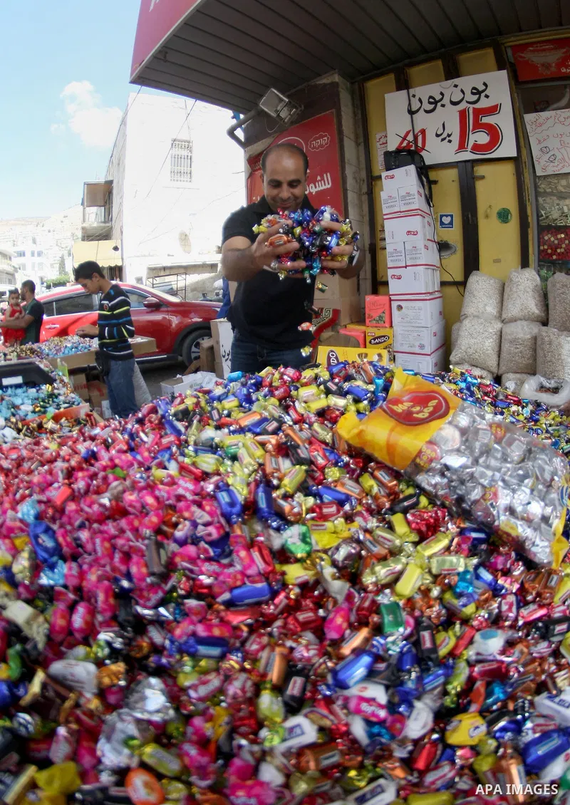 A Palestinian man sales sweets during the preparation for the Eid al-Adha festival in the West Bank city of Nablus, Oct. 02, 2014. Muslims worldwide are celebrating Eid al-Adha, or Feast of the Sacrifice, commemorating G...
