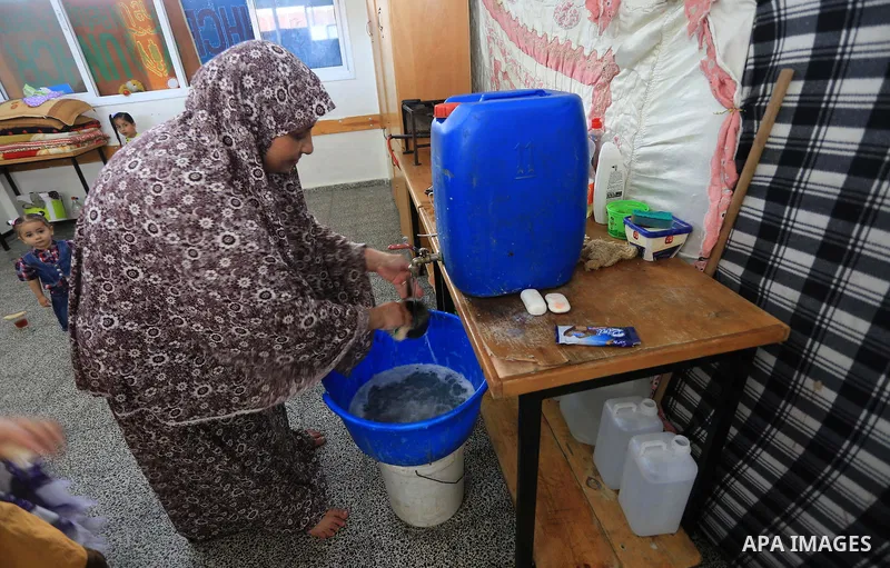 A Displaced Palestinian woman washes on the first day of Eid al-Adha or or the feast of sacrifice at a UN School where they took refuge during the heavy fighting in Gaza city on October 4, 2014. Muslims around the world...