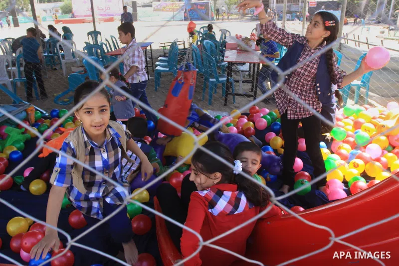 Palestinian children enjoy in an amusement park on the second day of Eid al-Adha or the feast of sacrifice in Gaza city on October 5, 2014. The religious festival, celebrated by a total of about 1.5 billion Muslims aroun...
