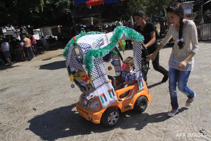 Palestinian children enjoy in an amusement park on the second day of Eid al-Adha or the feast of sacrifice in Gaza city on October 5, 2014. The religious festival, celebrated by a total of about 1.5 billion Muslims aroun...