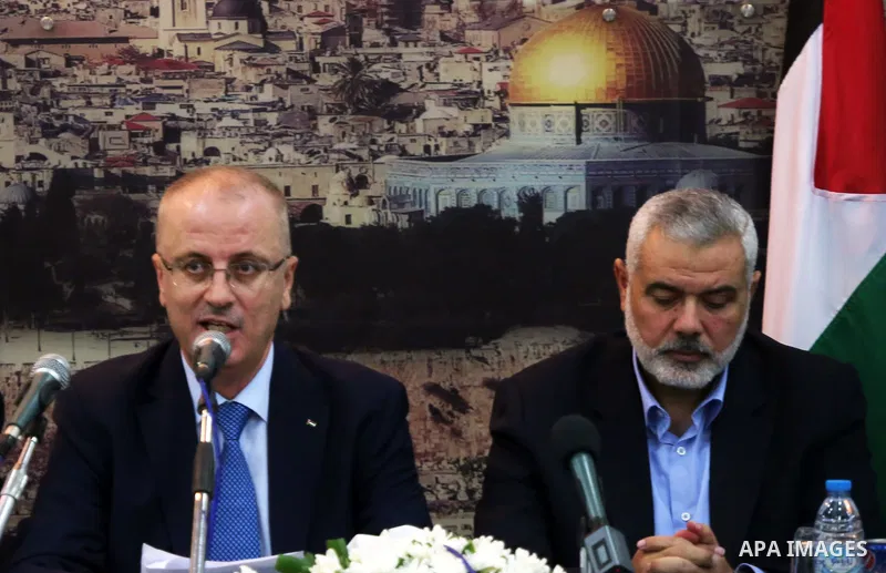 Palestinian Prime Minister Rami Hamdallah speaks during his visit to senior Hamas leader Ismail Haniyeh, at Haniyeh's house in Gaza city on October 9, 2014. The Palestinian unity government which took the oath of office...
