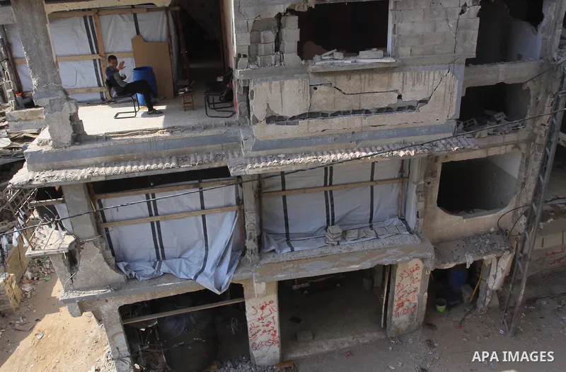 A Palestinian man sits inside his house that was destroyed during the devastating 50-day war between Israel and Hamas at Al-Shojae'ya neighborhood east of Gaza City on October 12, 2014. Ahead of a donors conference in Ca...