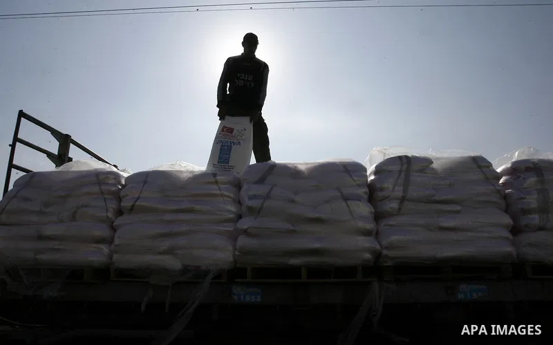 A Palestinian worker offloads a truck loaded with aid after it arrived in the Gaza Strip from Israel through the Kerem Shalom crossing in Rafah in southern Gaza Strip on October 12, 2014. Some 50 countries are attending...