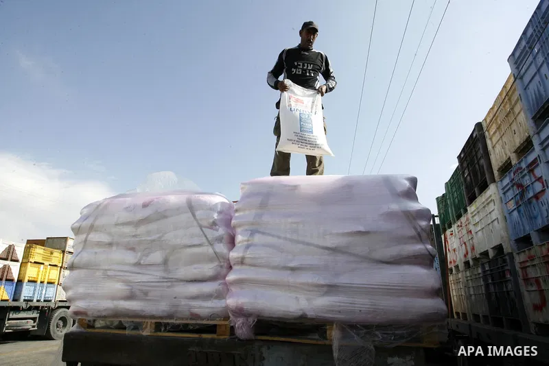 A Palestinian worker offloads a truck loaded with aid after it arrived in the Gaza Strip from Israel through the Kerem Shalom crossing in Rafah in southern Gaza Strip on October 12, 2014. Some 50 countries are attending...