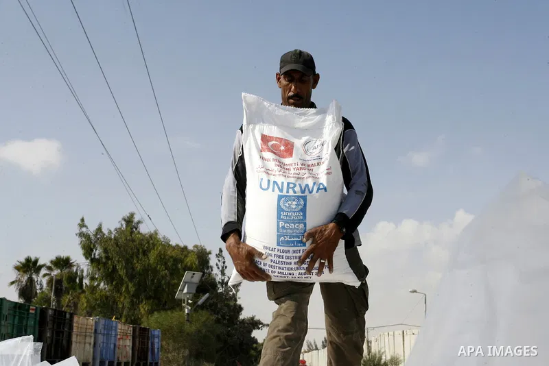 A Palestinian worker offloads a truck loaded with aid after it arrived in the Gaza Strip from Israel through the Kerem Shalom crossing in Rafah in southern Gaza Strip on October 12, 2014. Some 50 countries are attending...