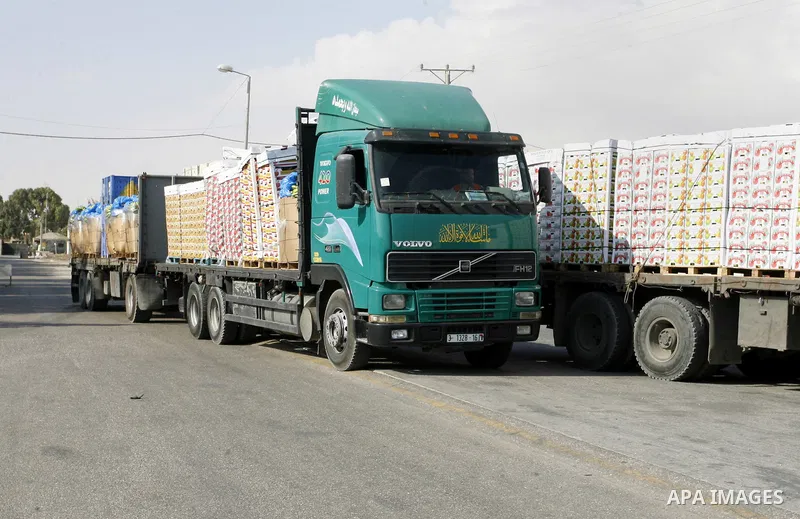 Trucks loaded with goods enters the Gaza Strip from Israel through the Kerem Shalom crossing in Rafah in southern Gaza Strip on October 12, 2014. Some 50 countries are attending a Gaza Donor Conference in Egypt, with Pal...