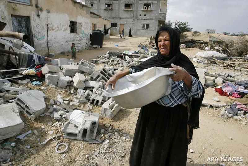 A Palestinian woman stands amid the rubble of her home which was destroyed during the 50-day conflict between Hamas militants and Israel, in the southern Gaza Strip town of Rafah on October 12, 2014. Some 50 countries ar...
