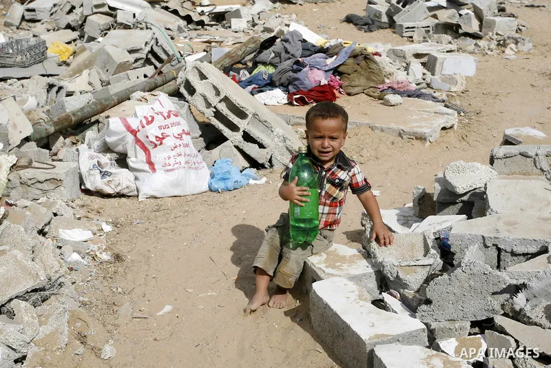 A Palestinian boy sits on the rubble of his family's home which was destroyed during the 50-day conflict between Hamas militants and Israel, in the southern Gaza Strip town of Rafah on October 12, 2014. Some 50 countries...