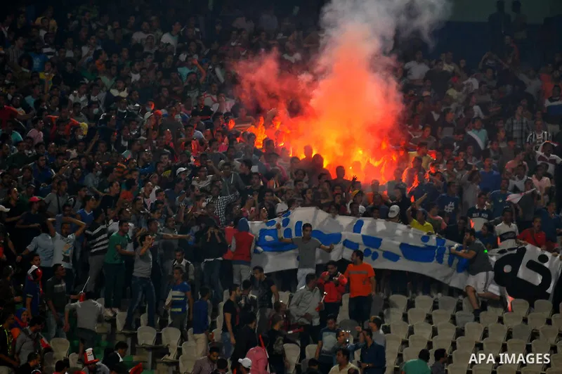 Egyptian soccer fans known as "Ultras" shout slogans against the government and police while holding a flare during the African Nations Cup qualifying soccer match between Egypt and Botswana, in Cairo October 15, 2014. T...
