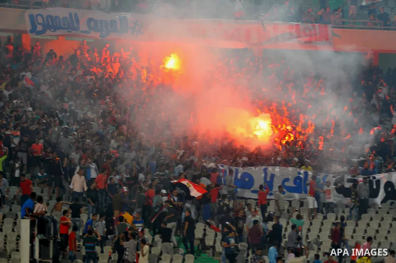 Egyptian soccer fans known as "Ultras" shout slogans against the government and police while holding a flare during the African Nations Cup qualifying soccer match between Egypt and Botswana, in Cairo October 15, 2014. T...