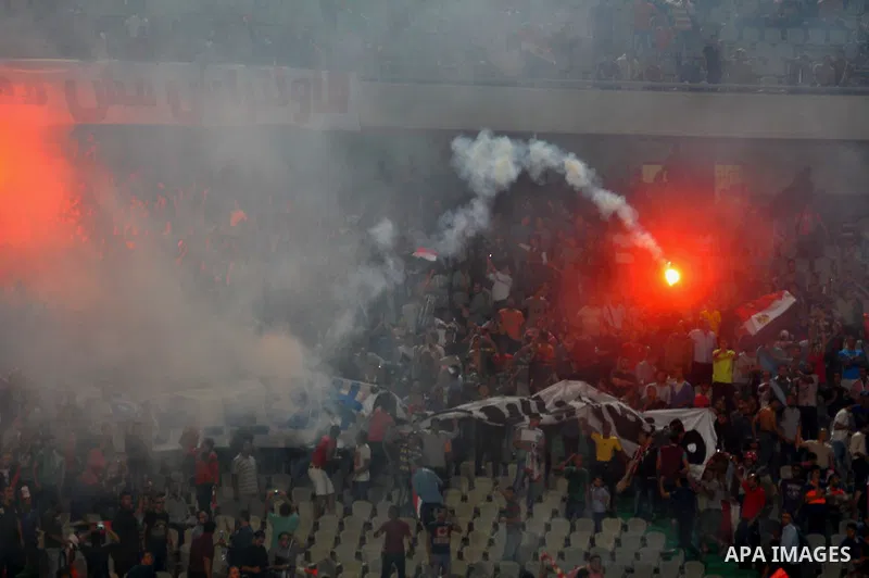 Egyptian soccer fans known as "Ultras" shout slogans against the government and police while holding a flare during the African Nations Cup qualifying soccer match between Egypt and Botswana, in Cairo October 15, 2014. T...