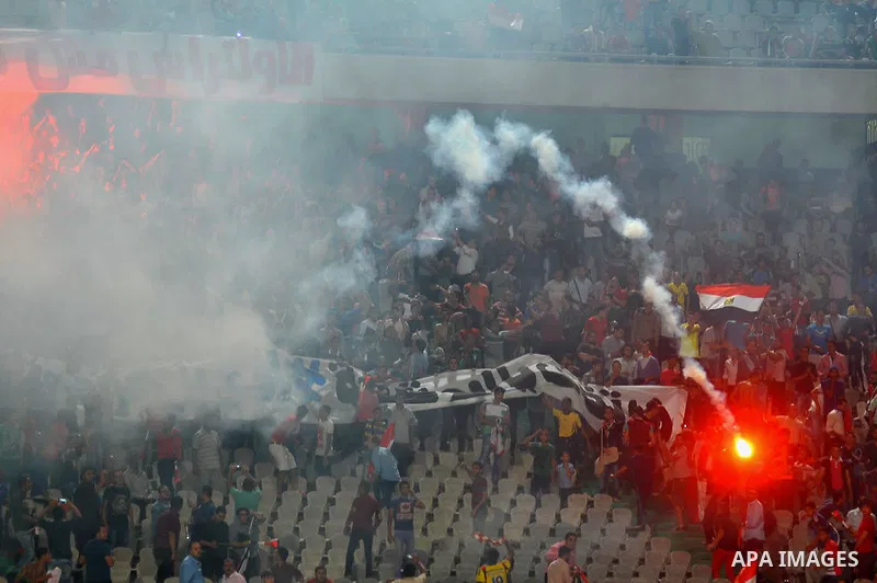 Egyptian soccer fans known as "Ultras" shout slogans against the government and police while holding a flare during the African Nations Cup qualifying soccer match between Egypt and Botswana, in Cairo October 15, 2014. T...