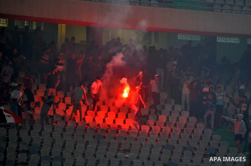 Egyptian soccer fans known as "Ultras" shout slogans against the government and police while holding a flare during the African Nations Cup qualifying soccer match between Egypt and Botswana, in Cairo October 15, 2014. T...