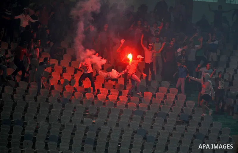 Egyptian soccer fans known as "Ultras" shout slogans against the government and police while holding a flare during the African Nations Cup qualifying soccer match between Egypt and Botswana, in Cairo October 15, 2014. T...