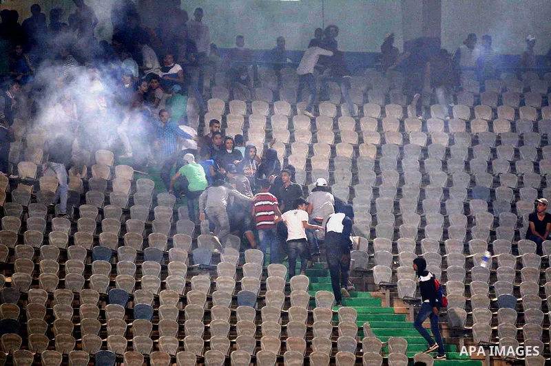 Egyptian soccer fans known as "Ultras" shout slogans against the government and police while holding a flare during the African Nations Cup qualifying soccer match between Egypt and Botswana, in Cairo October 15, 2014. T...