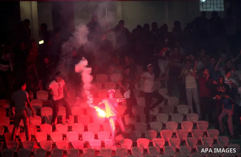 Egyptian soccer fans known as "Ultras" shout slogans against the government and police while holding a flare during the African Nations Cup qualifying soccer match between Egypt and Botswana, in Cairo October 15, 2014. T...