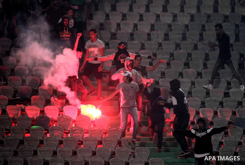 Egyptian soccer fans known as "Ultras" shout slogans against the government and police while holding a flare during the African Nations Cup qualifying soccer match between Egypt and Botswana, in Cairo October 15, 2014. T...
