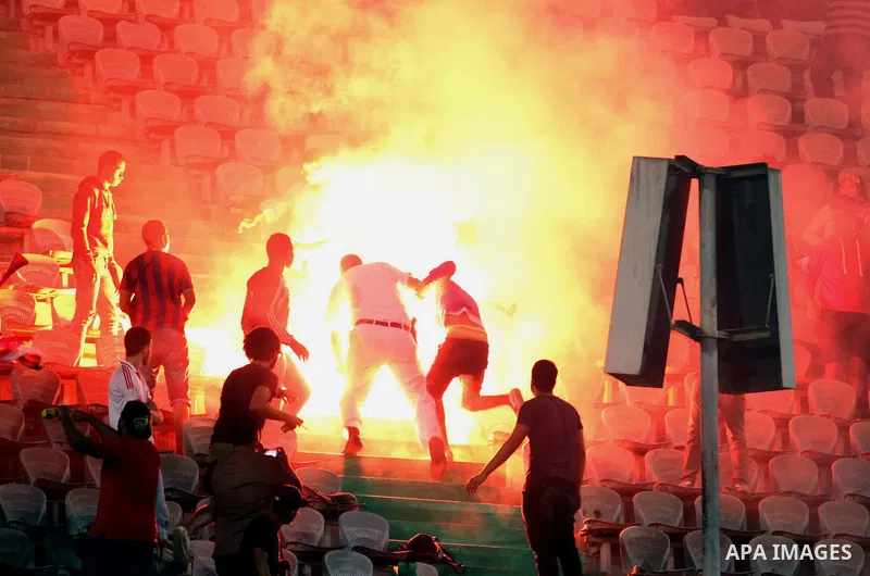Egyptian soccer fans known as "Ultras" shout slogans against the government and police while holding a flare during the African Nations Cup qualifying soccer match between Egypt and Botswana, in Cairo October 15, 2014. T...