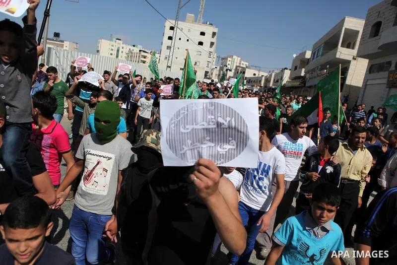 Palestinian supporters of Hamas take part in a protest against Israel restrictions at the Al-Aqsa Mosque compound in the city centre of the West Bank city of Hebron on October 17,2014. For the third week in a row, Israel...