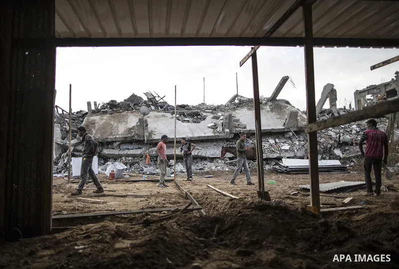 Palestinian families build a shelter to protect them from winter rains, next to their destroyed house that witnesses said were destroyed during a seven-week Israeli offensive, on a rainy day in the town of Beit Hanoun, t...